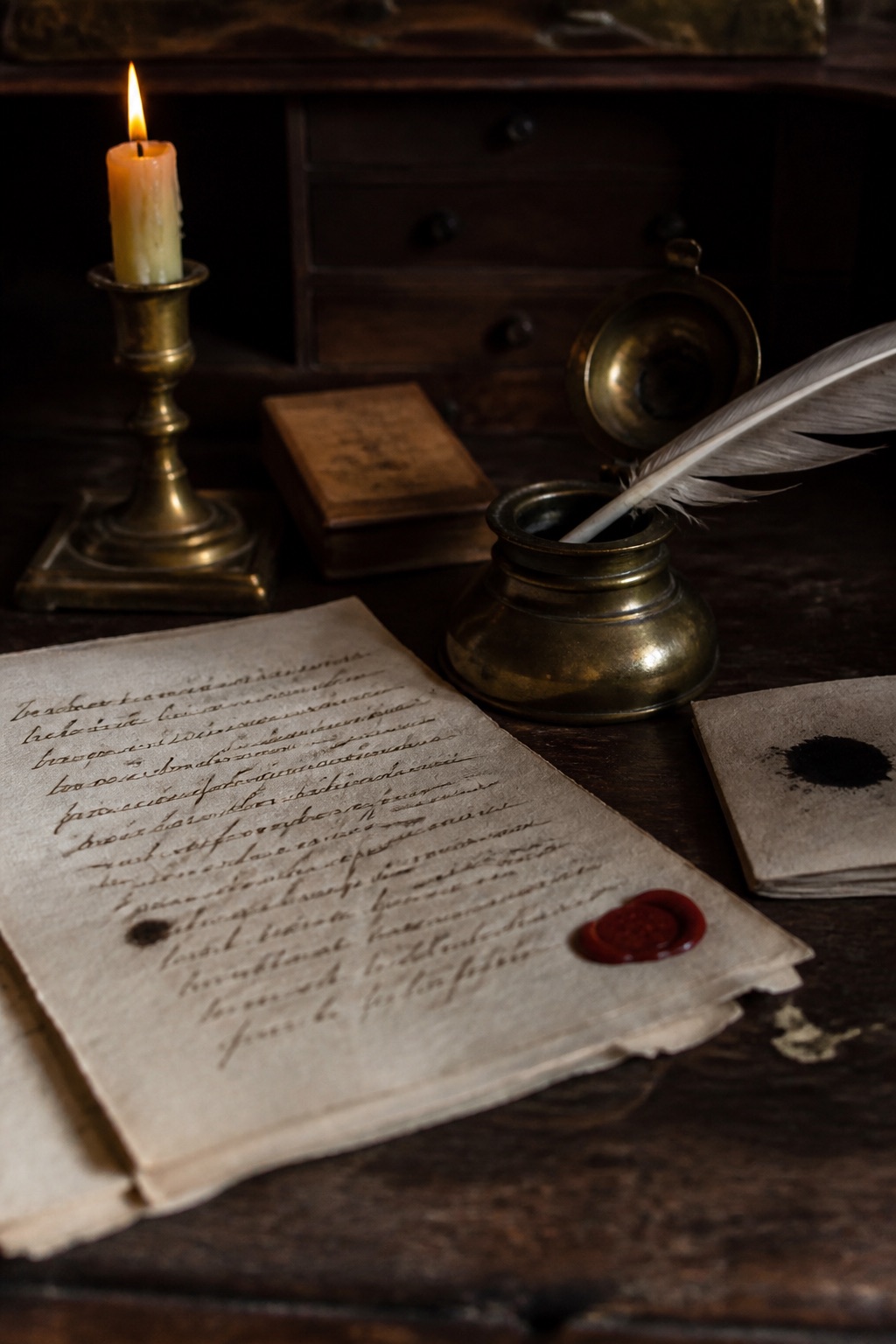 Plume, encrier et manuscrit à moitié rédigé sur un bureau éclairé à la chandelle